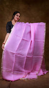 Woman holding a pink saree against a brown background