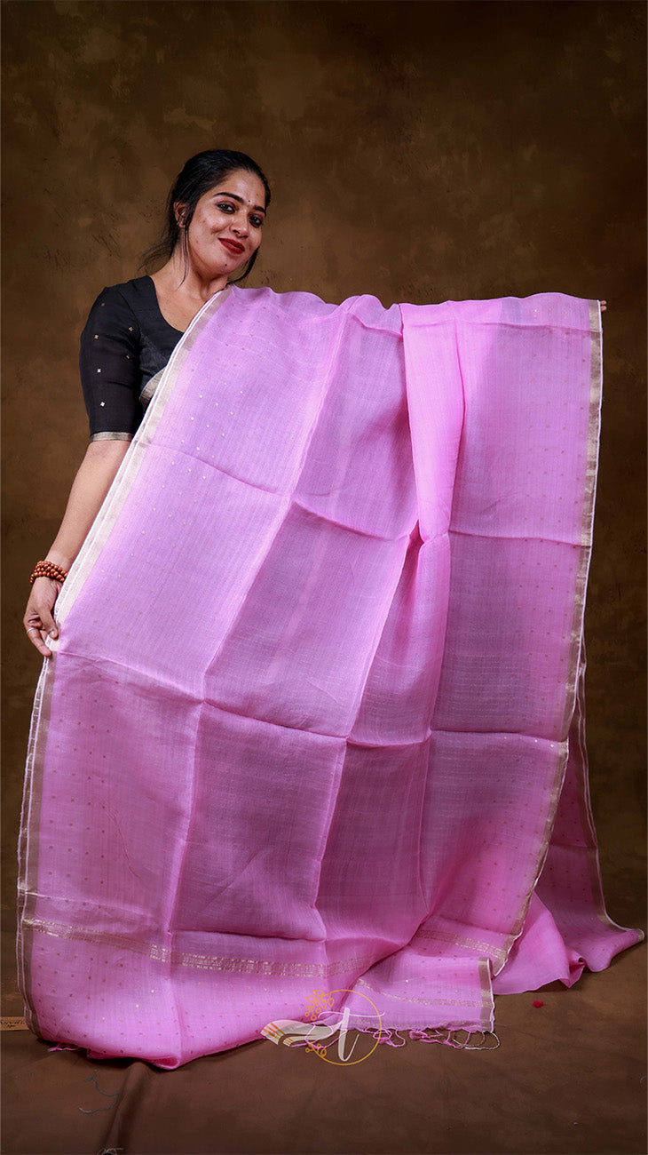 Woman holding a pink saree against a brown background