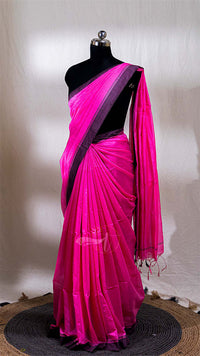 Pink saree with black border on a mannequin against a neutral background