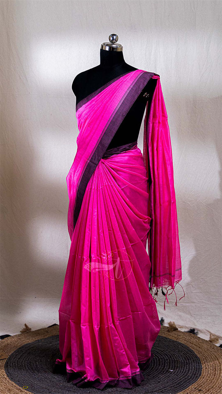 Pink saree with black border on a mannequin against a neutral background