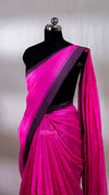Pink saree with black border on a mannequin against a plain background