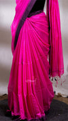 Pink saree with a black border on a plain background