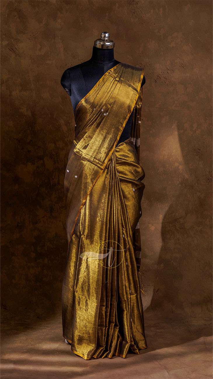 Gold saree on a mannequin against a brown background